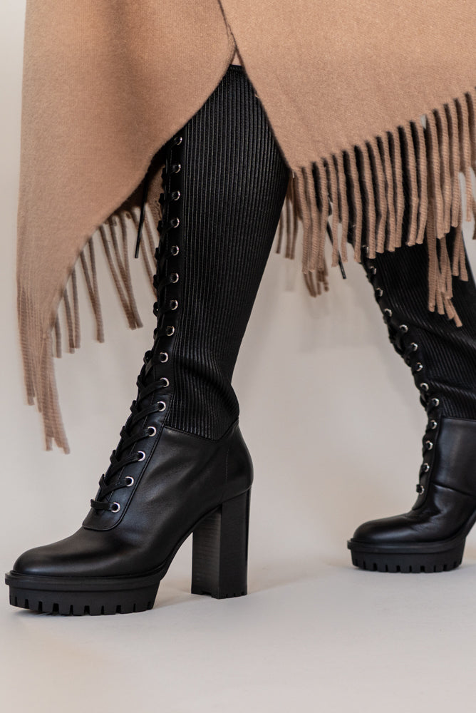 Made from black calf leather, the Martis High Knee Platform Boot features a combat sole that makes it trendy and practical. Perfect for facing any weather condition in style.