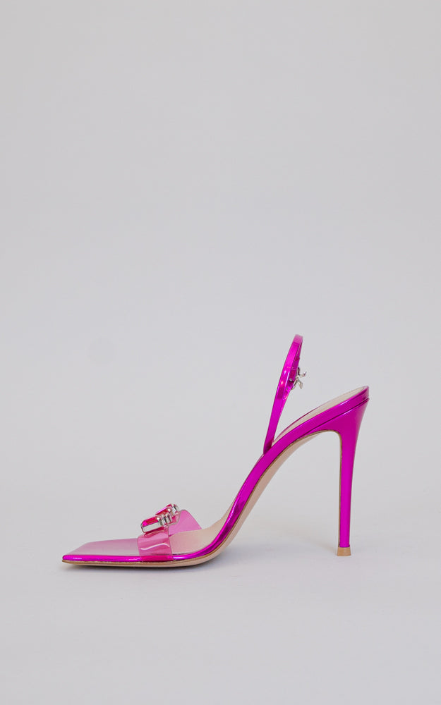 A squared-toe sandal with a stiletto heel. The ankle strap is embellished with a ribbon buckle and the front strap features see-through plexi with crystal gems.
