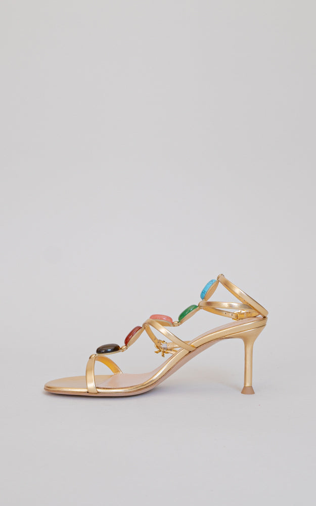 A gladiator sandal for the upcoming season. Standing on a 70mm stiletto heel, this round toe sandal has a gold ribbon buckle, and showcases the chakra-inspired natural cabochon stones. 