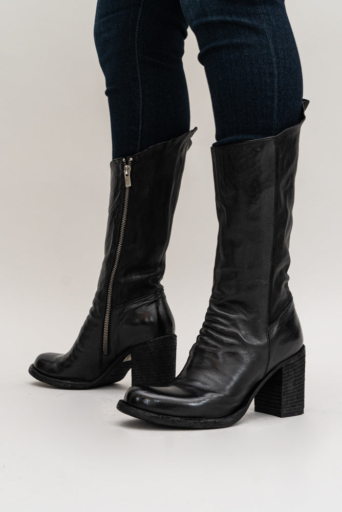 The 'Vernon' stacked leather heel boot is a mid-knee style, and has a side zipper for easy closure. This boot adds a flare to a classic black leather heeled boot. 